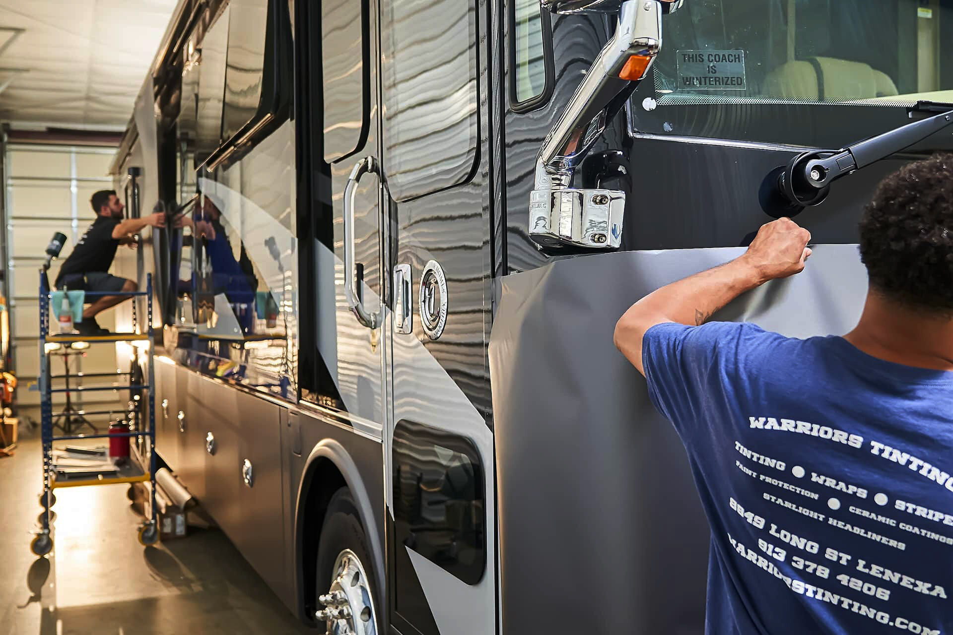 Warrior's KC installers applying vinyl to the front and side of a Tiffin motorcoach (project photo 121)